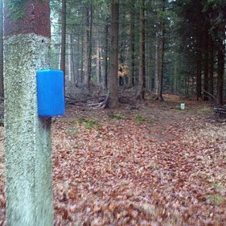 Krabička s turistickým zápisníkem na jednom z mnoha hraničních patníků.
